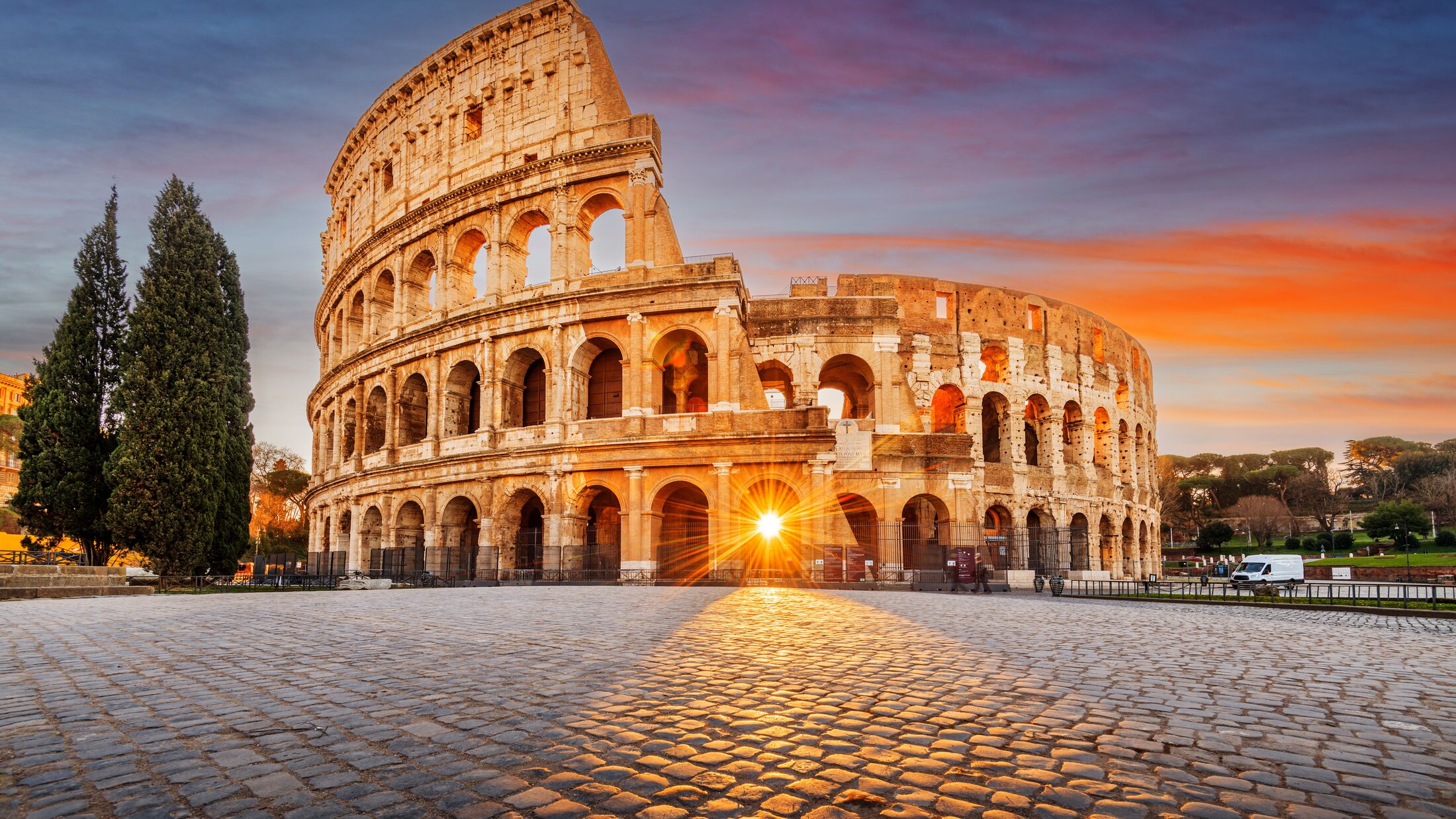 Rome, Italy at the Colosseum Amphitheater with the sunrise through the entranceway.