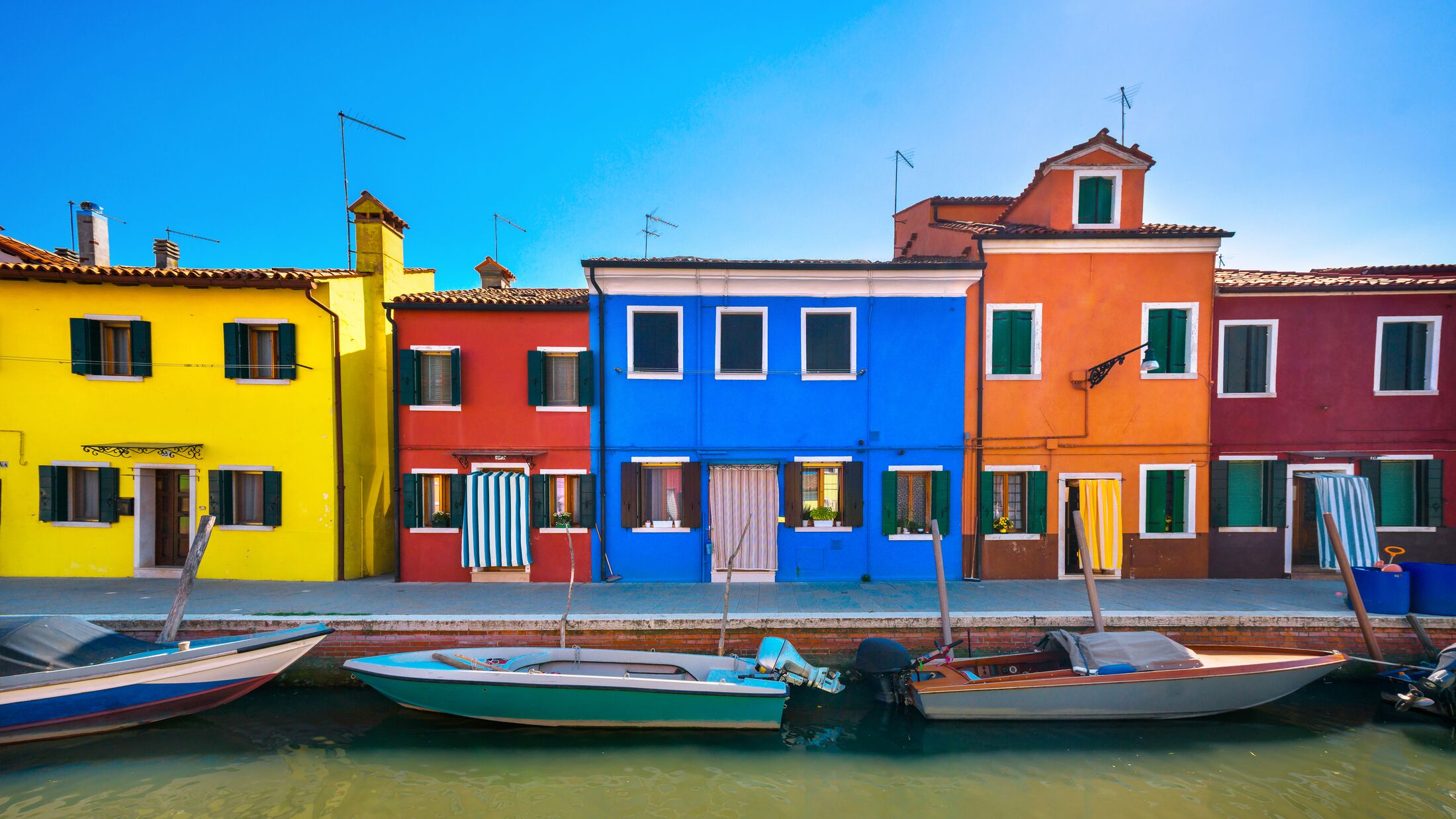 Venice landmark, Burano island canal, colorful houses and boats, Italy. Europe