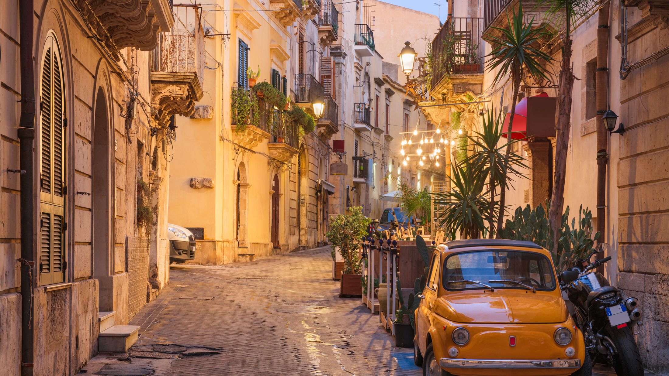 Syracuse, Italy cityscape and street scene at twilight.