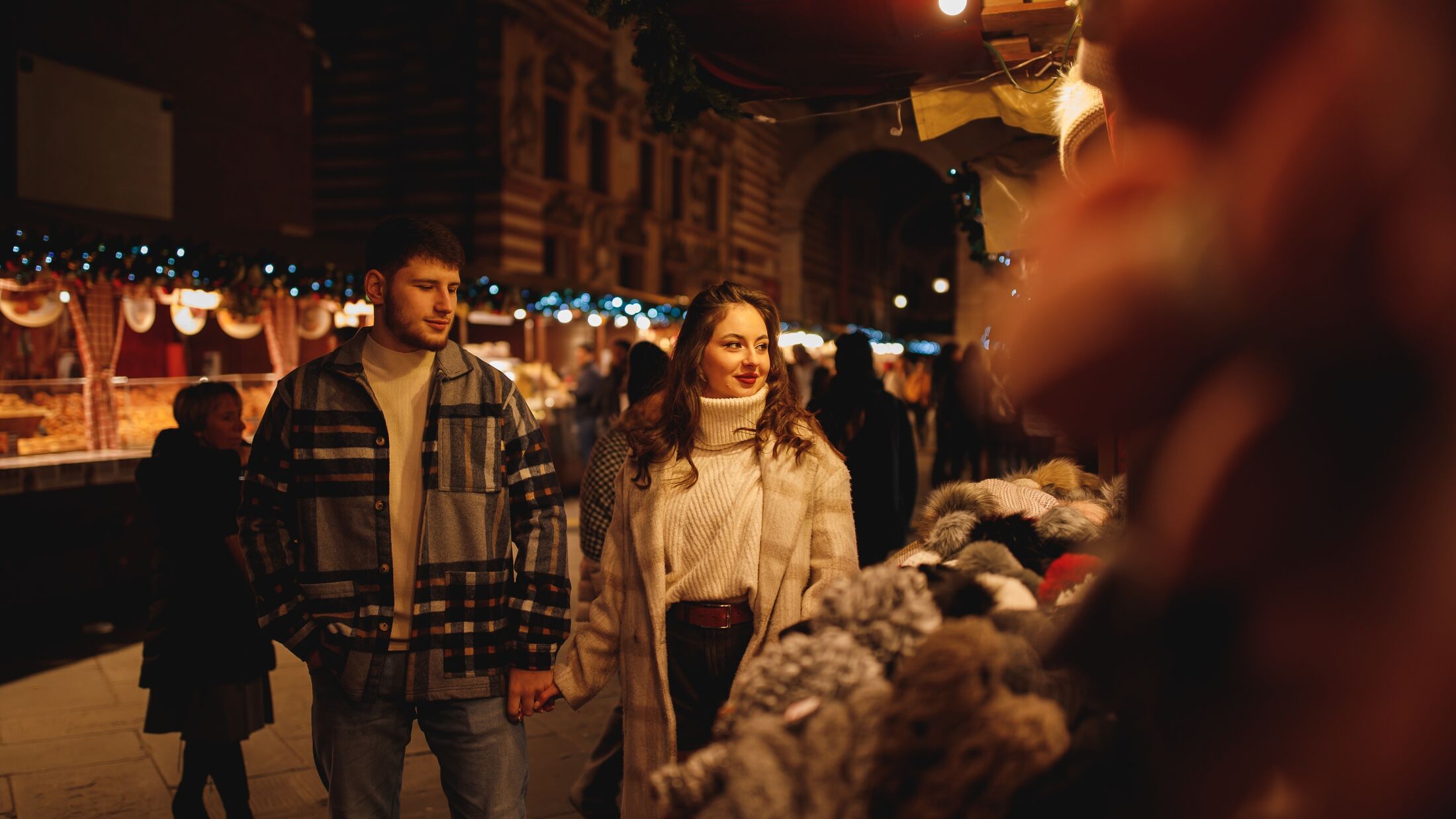 Young couple in love walking at Italian Christmas market in Verona