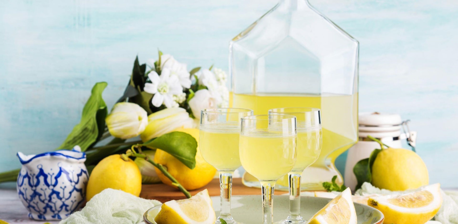 Home made limoncello served in stemmed glasses. Summer still life