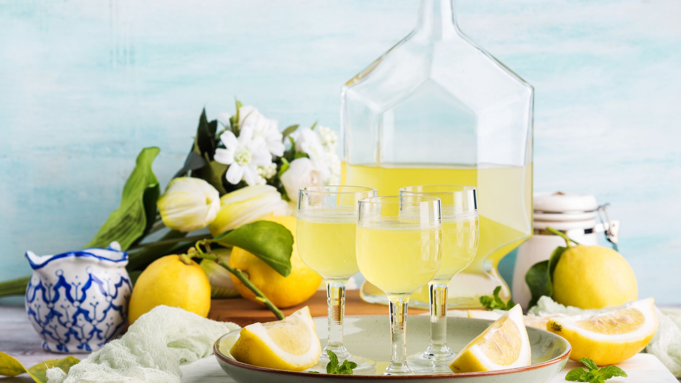 Home made limoncello served in stemmed glasses. Summer still life