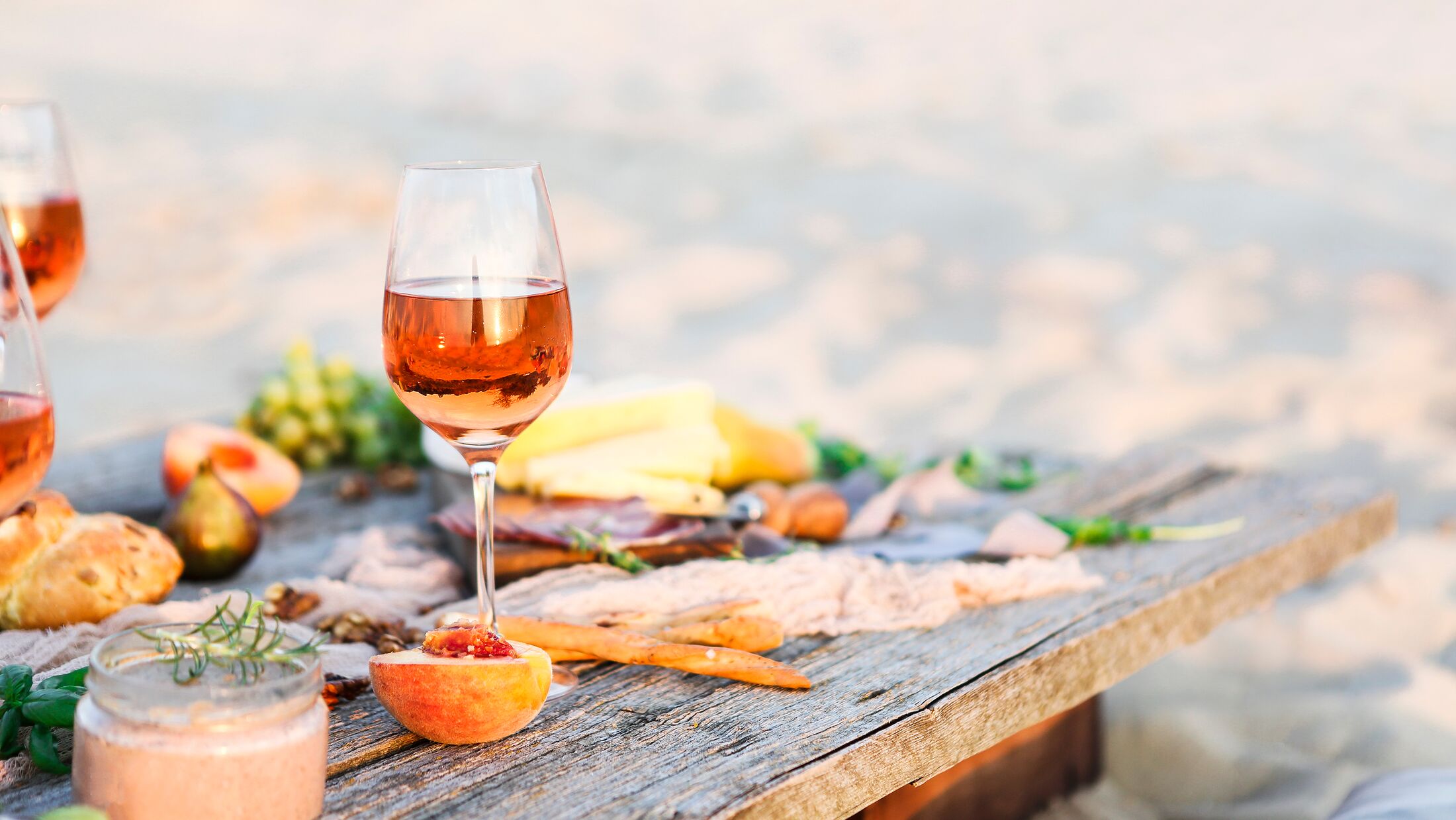 Glass of rose wine on rustic table. Food and drink background